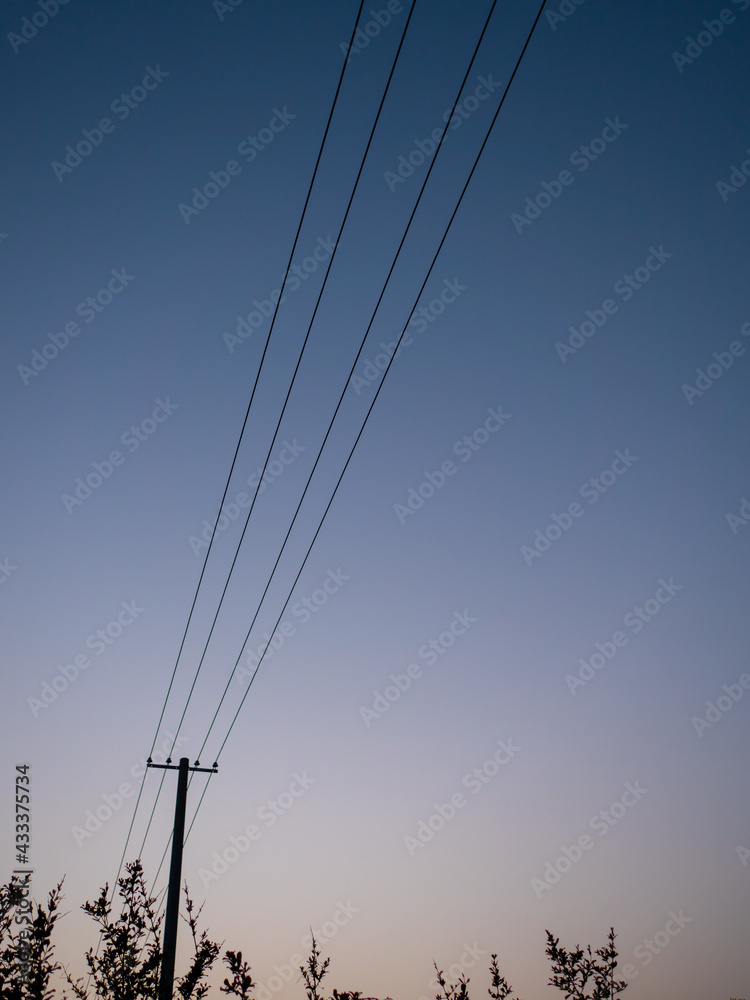 In summer, on the outskirts of the evening, the sky becomes dim, and telephone poles and wires stand by the roadside. In summer, on the outskirts of the evening, the sky becomes dim, and telephone poles and wires stand by the roadside.