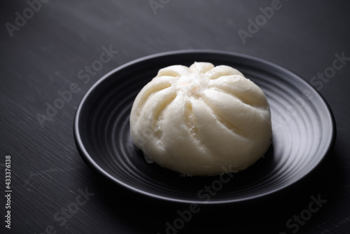 Steamed bun stuffed with minced pork on black background, Asian food