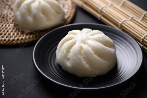 Steamed bun stuffed with minced pork on black background, Asian food