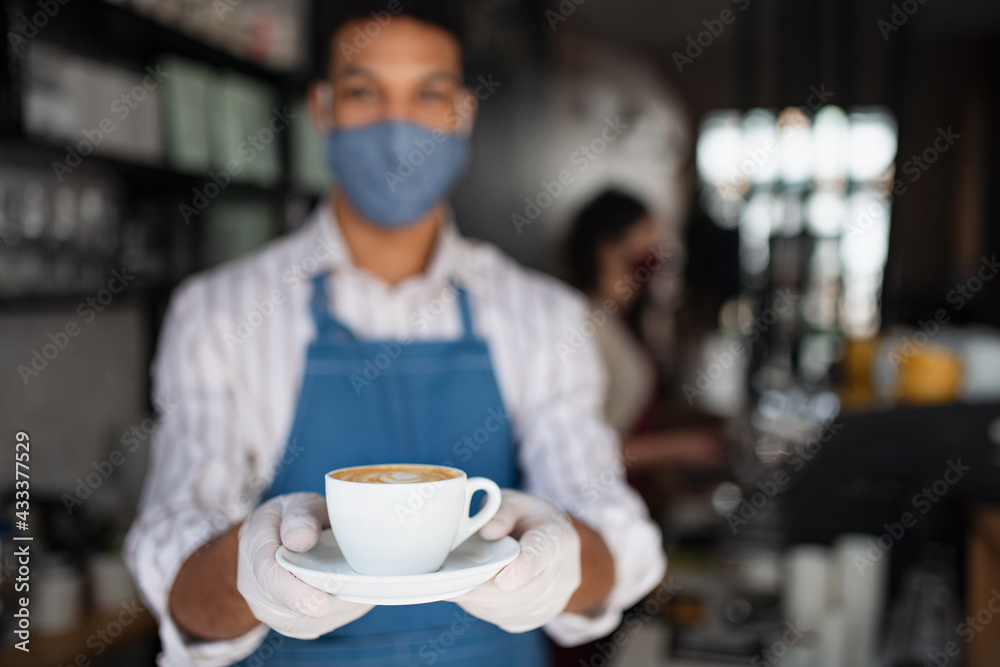 Portrait of waiter serving coffee in cafe, small business, coronavirus and new normal concept.