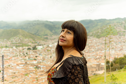 Mujer transgénero observando el cielo con vista a la ciudad de Cusco 