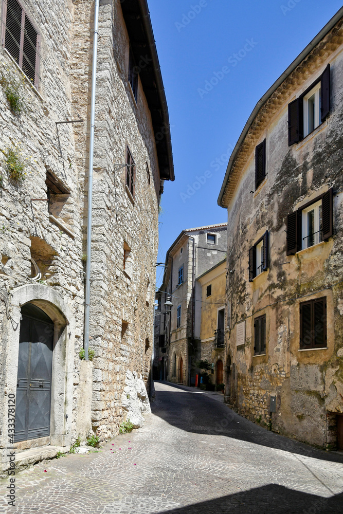 A street between old medieval stone buildings of Bassiano, historic town in Lazio region, Italy.