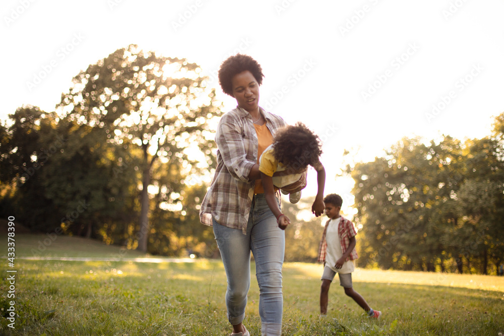 Fototapeta premium African American mother and daughter having fun outdoors. Time with kid.
