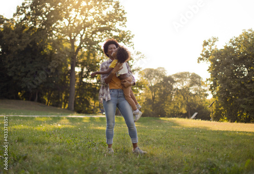 African American father and daughter having fun outdoors. With mom is always fun.