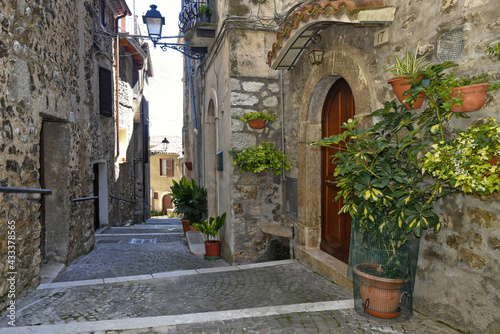 A street between old medieval stone buildings of Bassiano, historic town in Lazio region, Italy. © Giambattista