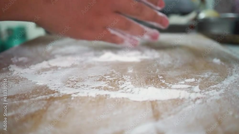 Cook hands kneading dough, sprinkling piece of dough with white wheat flour Cook hands kneading dough, sprinkling piece of dough with white wheat flour