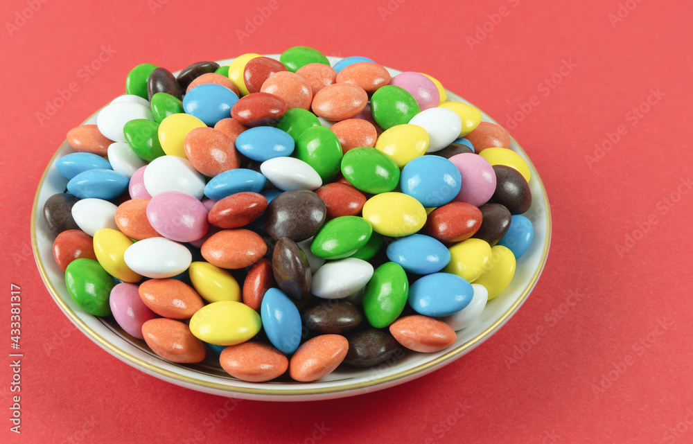 Round colored milk chocolate dragees on a plate Round colored milk chocolate dragees on a plate