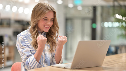 Excited Businesswoman Celebrating Success on Laptop in Office
