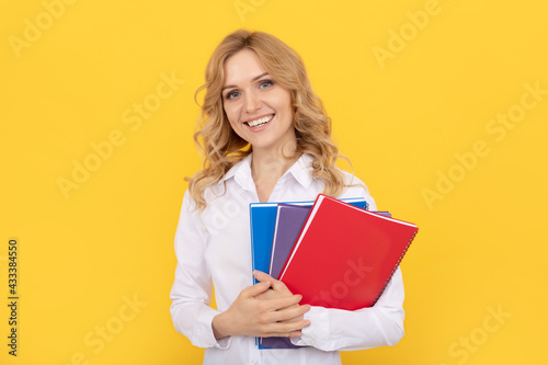 happy blonde businesswoman woman in white shirt hold notepad or notebook, education