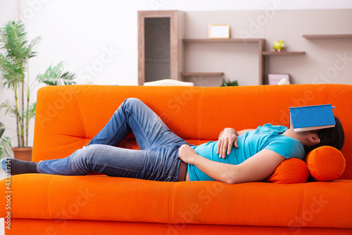 Young male student sitting on the orange sofa