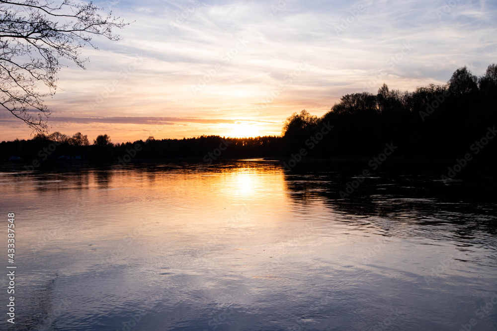 Spring sunset on the river, with blue skies, in a peaceful and quiet evening