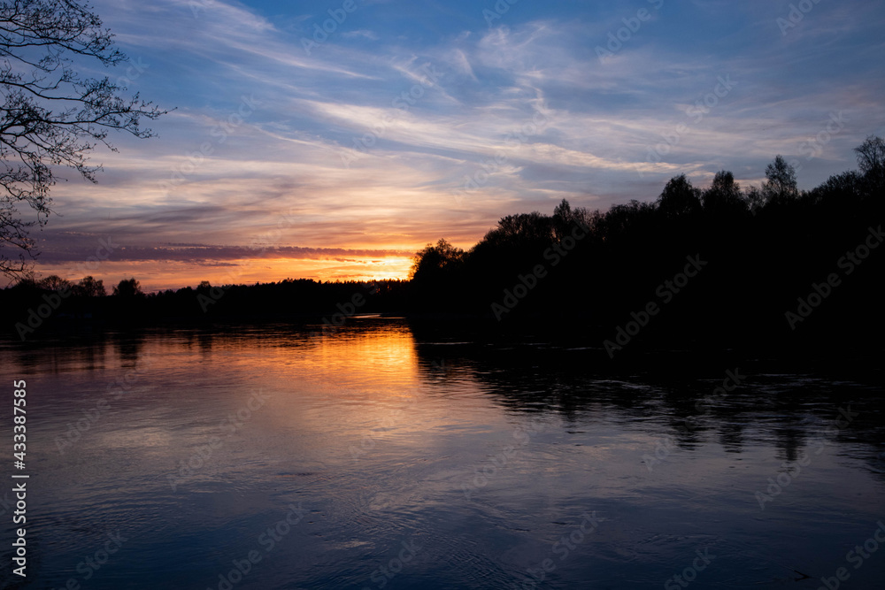 Spring sunset on the river, with blue skies, in a peaceful and quiet evening