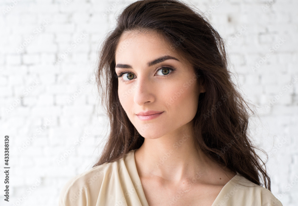 Beautiful brunette woman with long hair beauty eyes close up face over brick wall Beautiful brunette woman with long hair beauty eyes close up face over brick wall