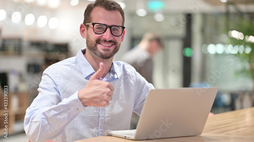 Thumbs Up by Positive Businessman working in Office