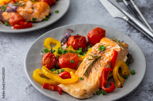 Baked red fish fillet Arctic char on a plates with vegetables close up, delicious hearty healthy dinner