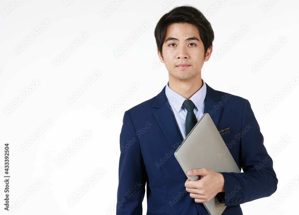 Young man looks indifferent but serious eyesight. Standing looking at the camera in the hand holding a notebook Symptoms express their readiness to present just waiting for the opportunity to come. Young man looks indifferent but serious eyesight. Standing looking at the camera in the hand holding a notebook Symptoms express their readiness to present just waiting for the opportunity to come.