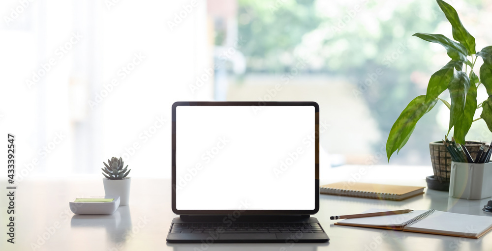 Fototapeta premium Digital tablet with white blank screen on table. workspace in modern office concept.