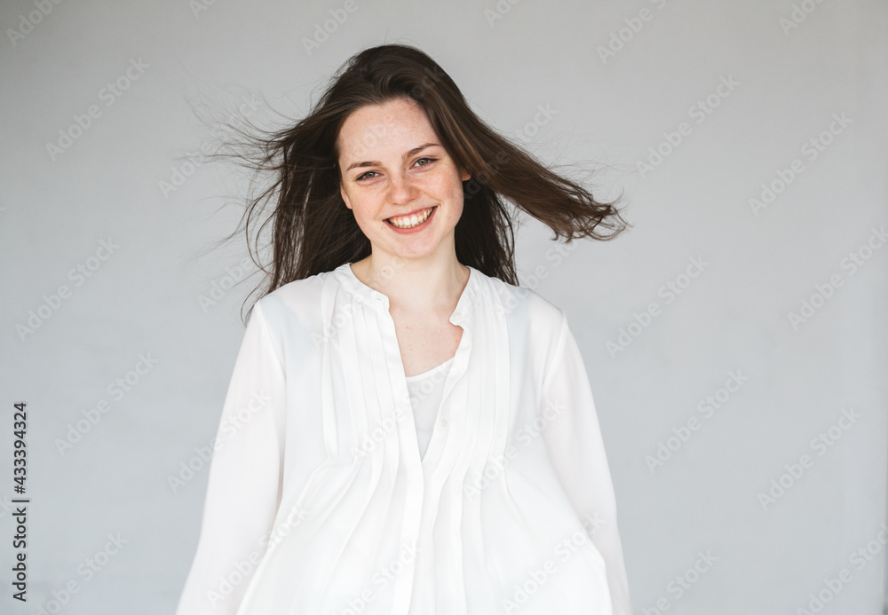 Young beautiful woman freckles face beaty natural healthy skin smile over gray Young beautiful woman freckles face beaty natural healthy skin smile over gray