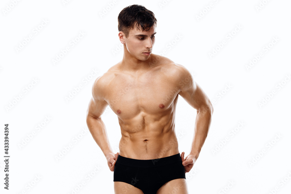 handsome man with a pumped-up torso holding his hands on his belt on isolated background handsome man with a pumped-up torso holding his hands on his belt on isolated background