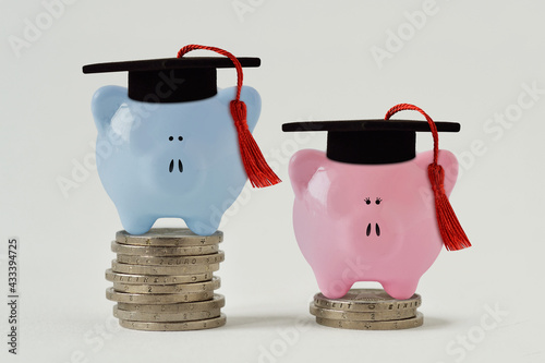 Canvas Blue and pink piggy bank with graduation hat on stack of coins - Concept of grad
