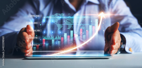 Businesswoman holding tablet with  growing virtual hologram of statistics, graph and chart.
 Business strategy development and growing growth plan. 