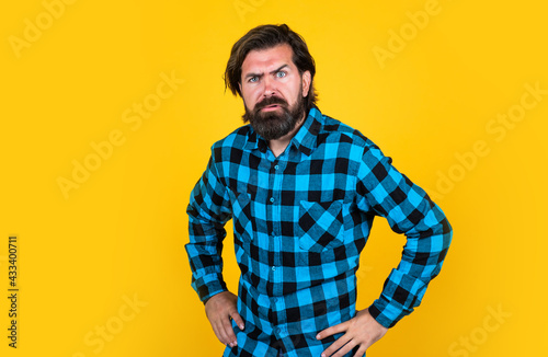 casual guy express human emotions. serious hipster with long hair and moustache. male beauty and fashion. barbershop concept. bearded man in checkered shirt