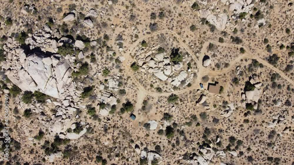 Lonely small hut surrounded by wild desert in top down aerial spinning view Lonely small hut surrounded by wild desert in top down aerial spinning view