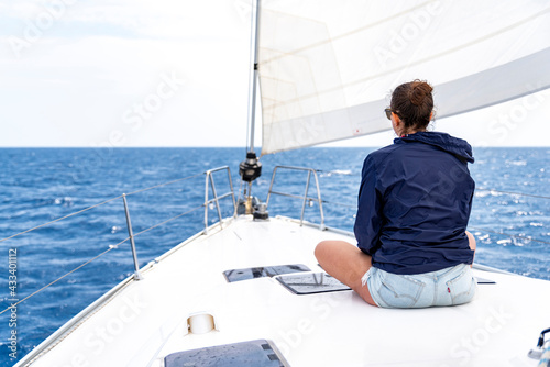 Girl in the bow of the boat enjoys sailing