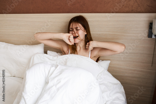 beautiful woman in bed under the covers stretching morning design interior model