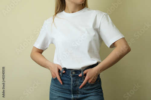 Young woman in blank t-shirt against beige background