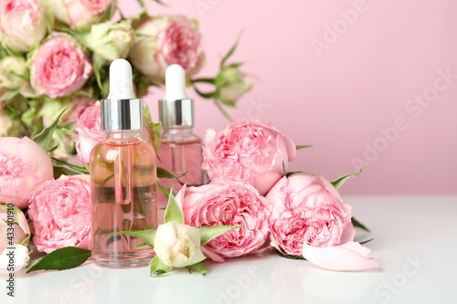 Skin care concept with essential rose oil on pink background