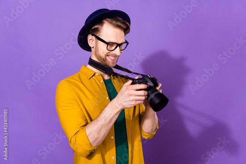 Profile side photo of young guy happy positive smile photographer look pictures camera isolated over purple color background