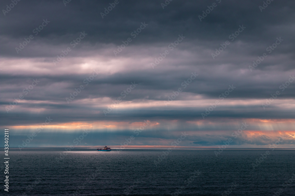 Obraz premium Ship at sea at sunset
