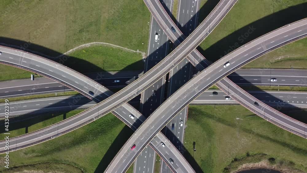 Aerial top down helicopter view of modern road interchange is junction that uses grade separation showing traffic flow moving in both way over the grade-separated interchanges 4k high resolution