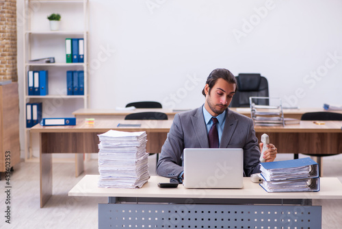 Young male employee unhappy with excessive work in the office © Elnur