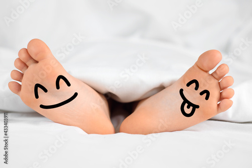 Children's feet with funny faces. Feet care, hygiene and rest photo