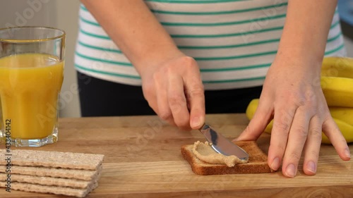 preparing a healthy breakfast in the kitchen - toast with peanut butter, banana