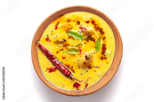 Close-up of Indian traditional kadhi or kadi pakora yogurt and gram flour and turmeric served hot in a clay bowl. Over a white background.
 photo