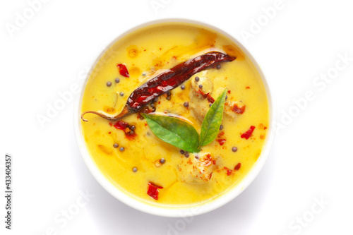 Close-up of Indian traditional kadhi or kadi pakora yogurt and gram flour and turmeric served hot in a white ceramic bowl. Over a white background.
 photo