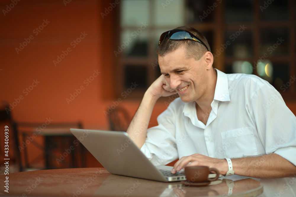 man using laptop with cup of coffee man using laptop with cup of coffee