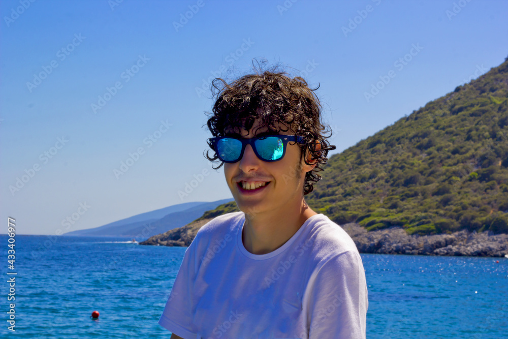 happy boy in sunglasses on the sea in sigacik, Turkey