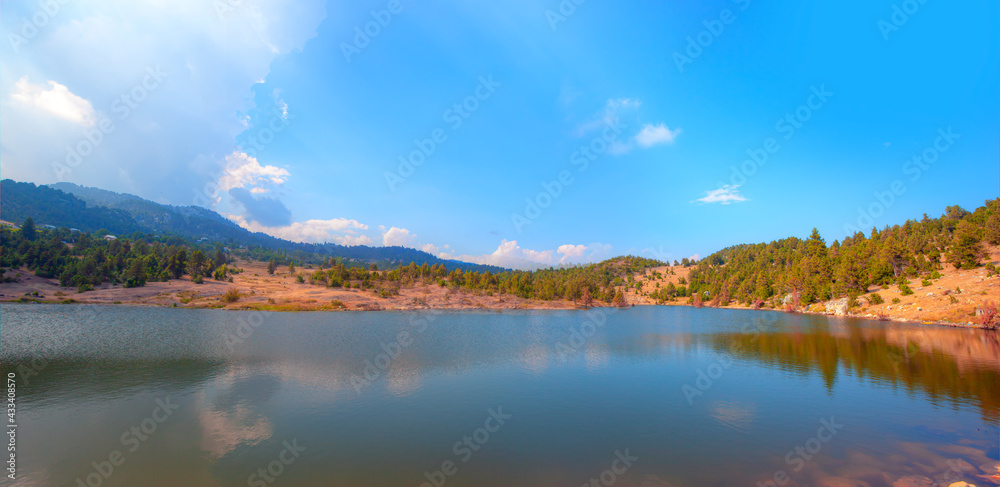 Clear reflecting lake with tree and clouds - Panoramic view on mountain lake in front of mountain range - Mersin Turkey