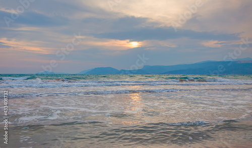 Nature in twilight period which including of sunrise over the green sea with blue mountains in the background