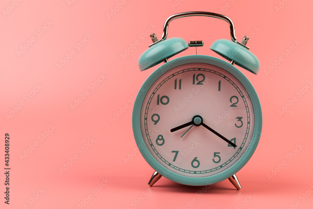 Old clock isolated on a pink background with space for text. Concept of time