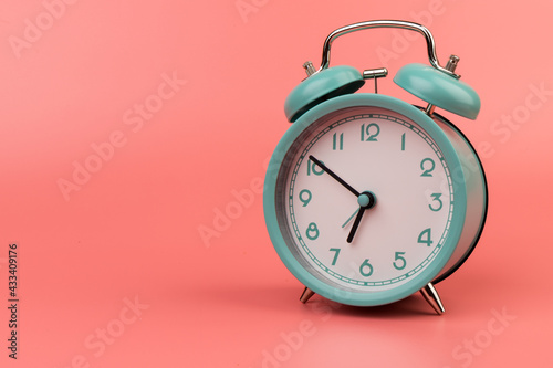 Old clock isolated on a pink background with space for text. Concept of time