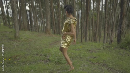 Mujer transgénero corriendo libremente por el interior del bosque 