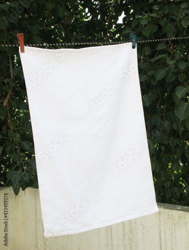 white towel isolated. White towel over green background. Terry towel shoot on open area.