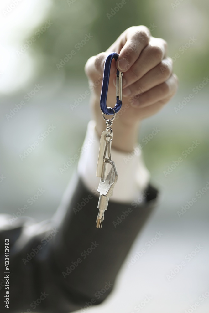 Close up of businessman holding key ring and key Close up of businessman holding key ring and key