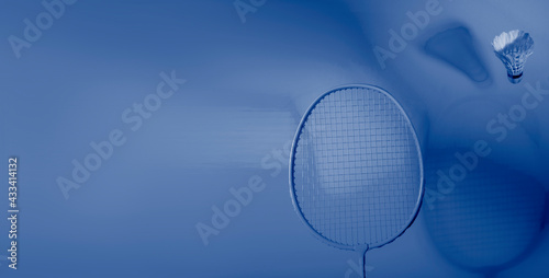 Badminton racket and shuttlecock on blue background. Professional sport concept