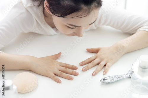 Young woman looking down fingernail